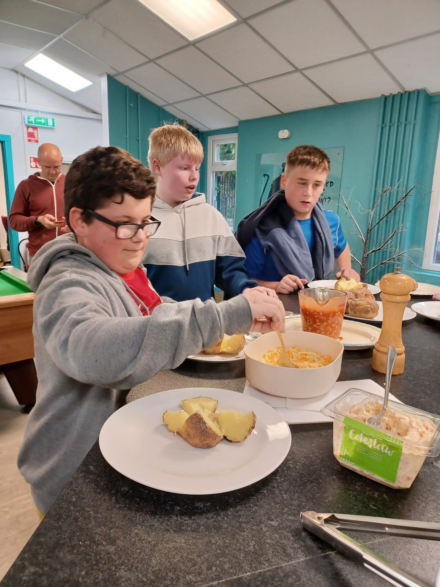 Young people serving themselves food at a Mentoring Plus youth club session