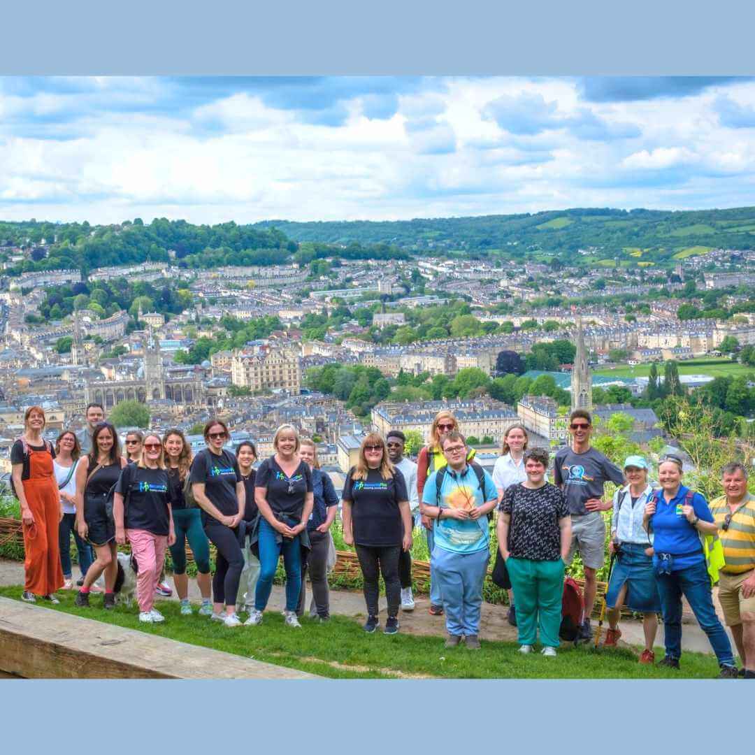 A group of Mentoring Plus walkers overlooking the city of Bath from a hillside viewpoint