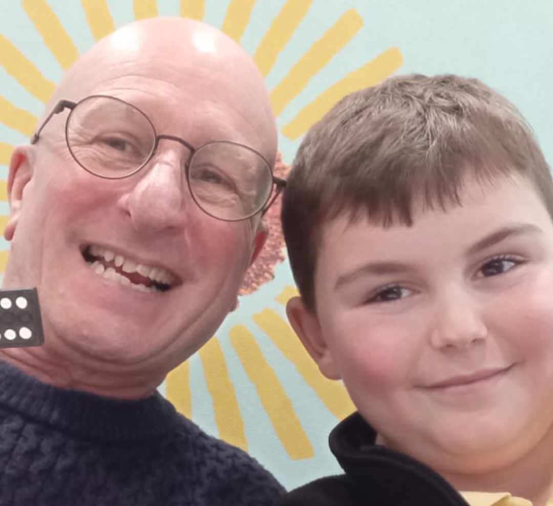 A mentor and young boy smiling together for a selfie