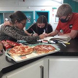 Young people doing work with pizza
