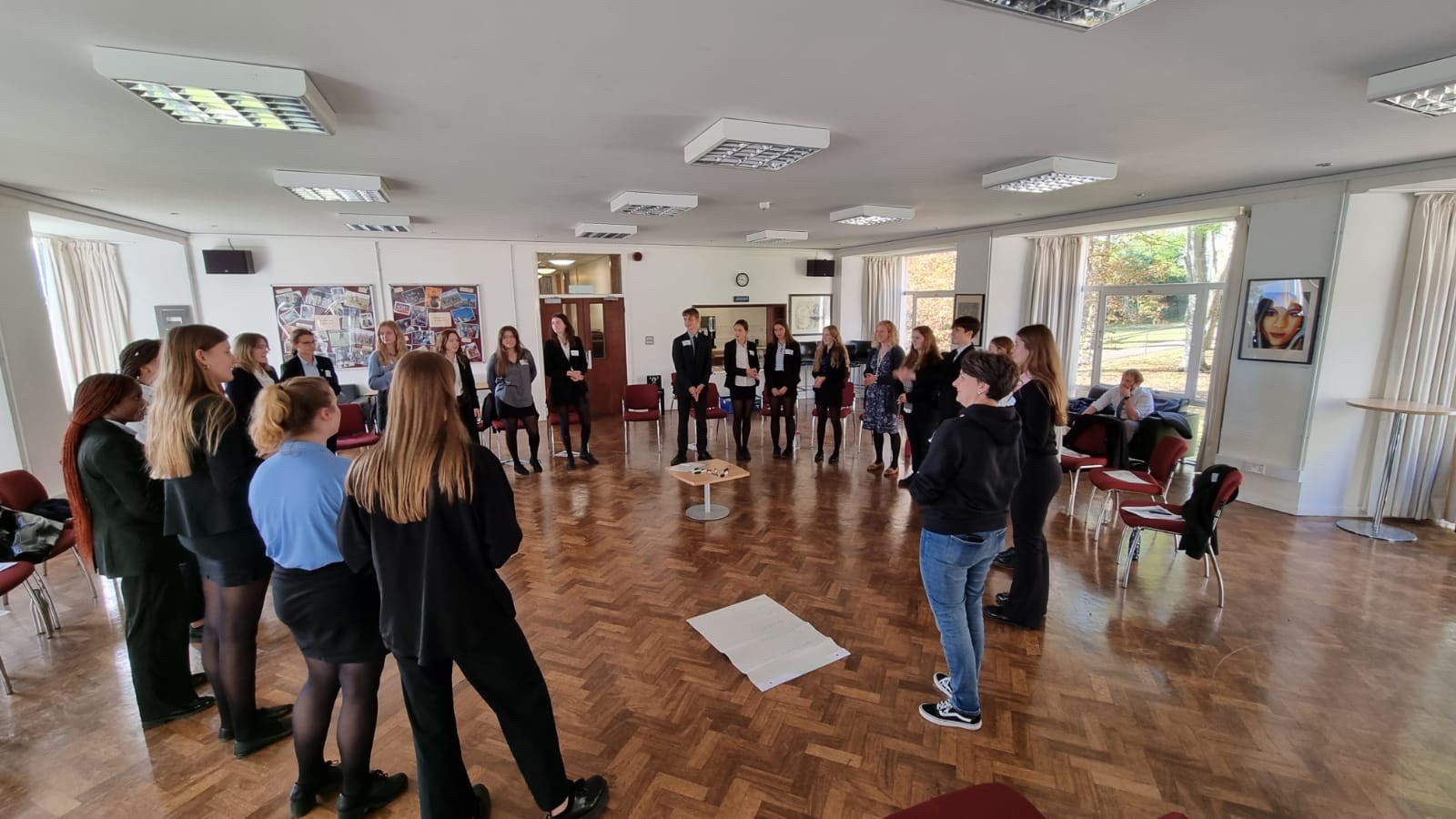 Students standing in a circle taking part in a peer mentoring group activity