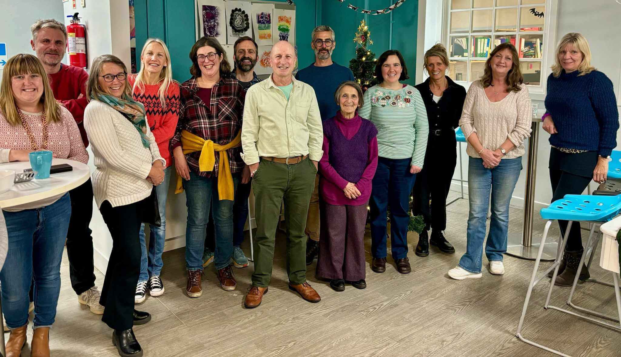 Mentoring Plus staff and volunteers smiling together at a Christmas gathering