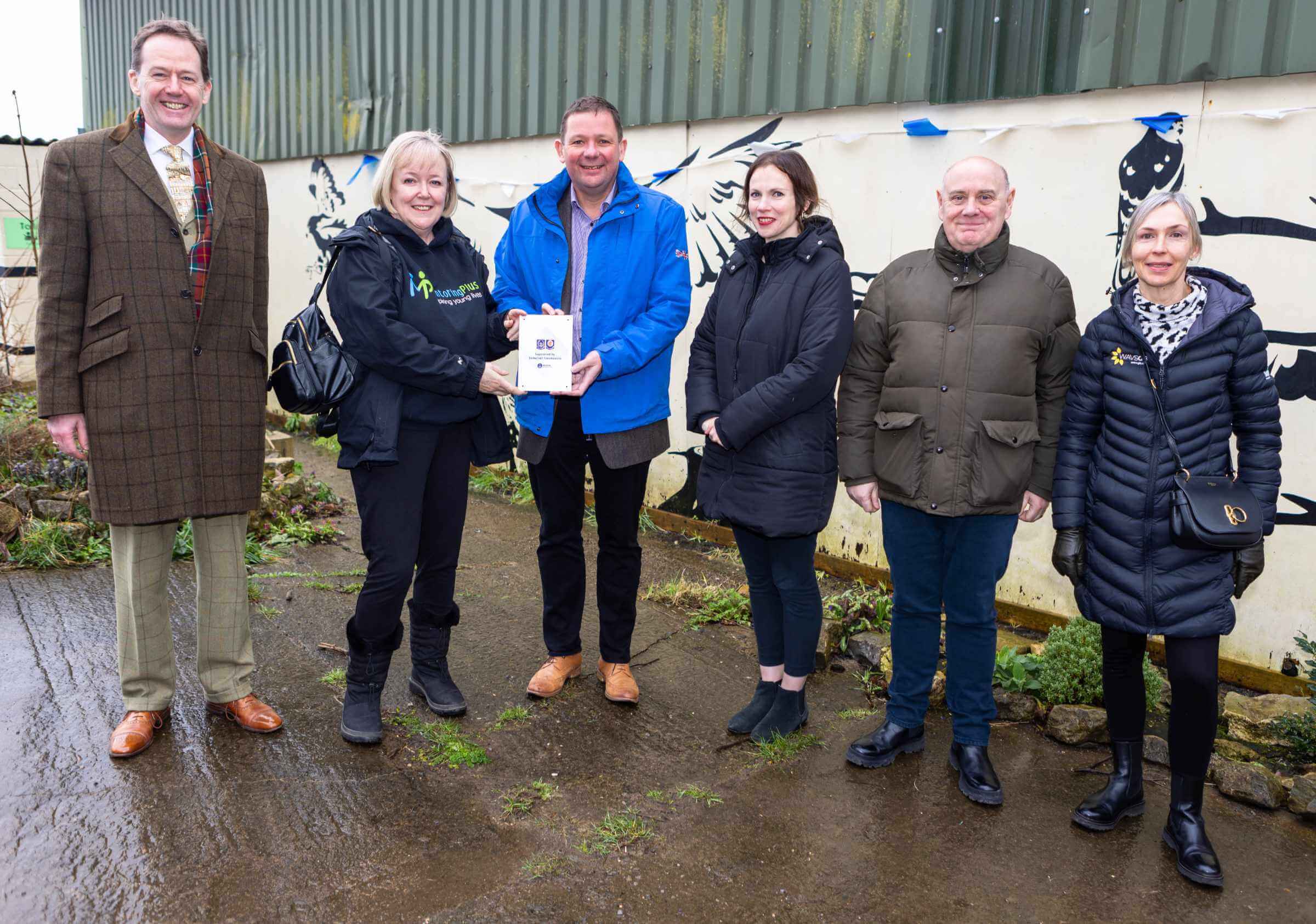 Mentoring Plus representatives receiving a certificate from Somerset Freemasons Charity outdoors