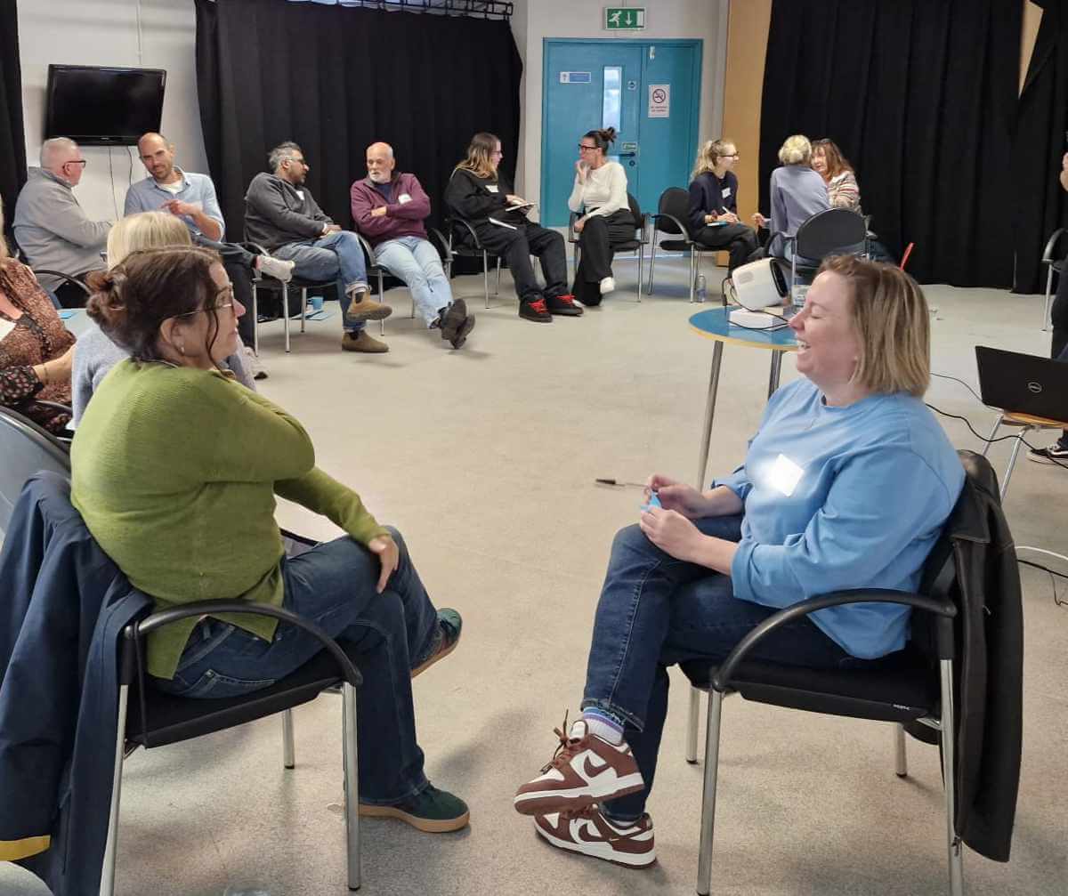 Volunteers taking part in a Mentoring Plus training session, chatting in pairs