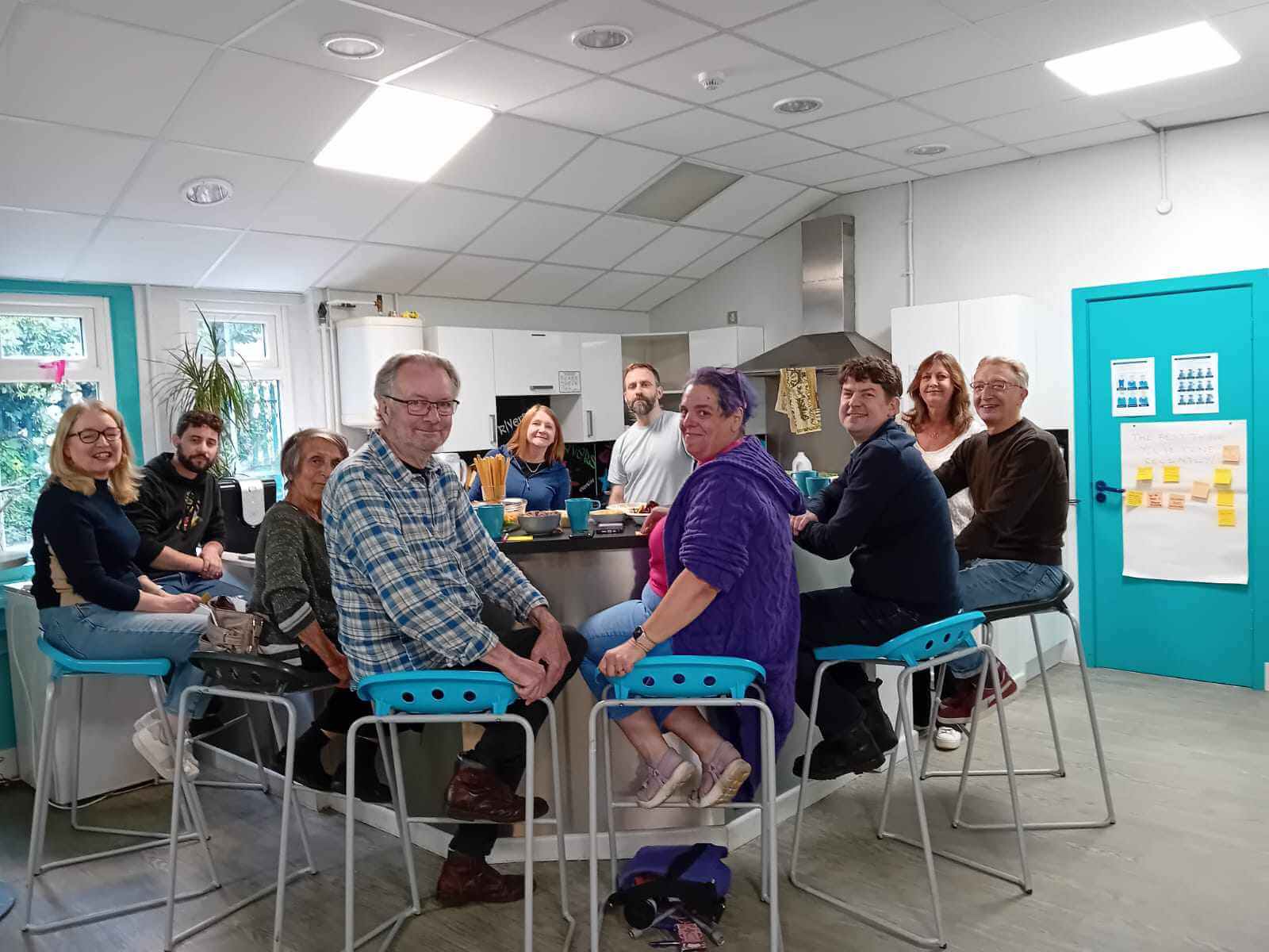 Mentoring Plus volunteer mentors sitting together around a kitchen island